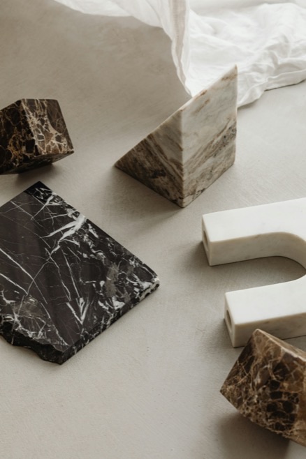 Marble material studies — dark and travertine stone blocks on a plaster table